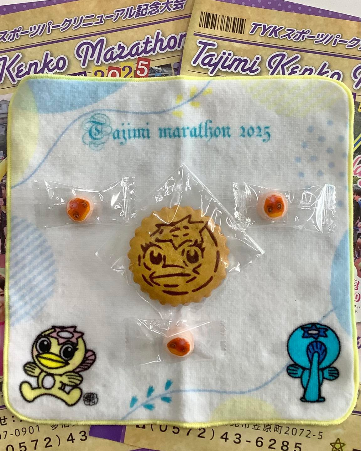 たじみ健康マラソン　ノベルティ第3弾

たじみ健康マラソン🏃またまた参加者の『お楽しみ』届きました✨✨

タオル、キャンディに続き、Newアイテムが出来上がってきましたよ😍

今回増えたモノ
　・
　・
　・
　・
そうです！うながっぱクッキーです🍪🍪🍪

キャンディもクッキーも、今回のマラソン大会の”スイーツエイド”として参加者の皆さんに提供させていただきます🏃

マラソンでのスイーツエイド🍬🍪、走る人にはテンションもモチベーションもあがりますよね⤴️⤴️✨ブースはコース上ではなく競技場内に設置予定です。約1000人のランナーの皆さん❗️是非お立ち寄りくださいね🤗

そして、このうながっぱキャンディ🍬は『鵜飼やっこ飴本舗』さん @ukaiyakkoamehonpo 、うながっぱクッキーは『ラ・メール・ブランシュ』さん @lamerblanche13  にお願いして作っていただきました✨✨

どちらも多治見の企業さんです‼️

私たちスタッフの「地元産スイーツでおもてなしをしたいっ」という思いをカタチにしていただき、ありがとうございます🥰🥰🥰
当日にお配りするのがとっても楽しみです💕
　
　

#多治見市 #多治見 #多治見市スポーツ協会 #笠原体育館 
#たじみ健康マラソン #たじみ健康マラソン2025 

#うながっぱ #糖分補給 
#うながっぱキャンディ  #鵜飼やっこ飴本舗 
#うながっぱクッキー #ラメールブランシュ 
#地元産スイーツ #スイーツエイド 

#マラソン大会のお楽しみ #着々と準備中 #次は何かな