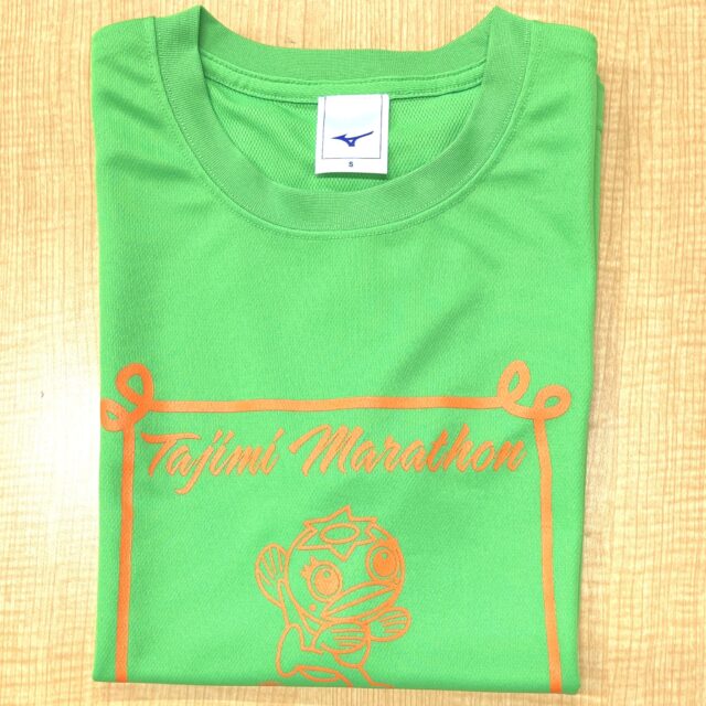 たじみ健康マラソン　ノベルティ第5弾

参加者へのお楽しみ🎁の中でもダントツ人気なのがTシャツ👕です。
今年はどんな色かなぁ～？と楽しみにしている人も多いことでしょう。

ようやく、今年のTシャツができあがってまいりました。
色は蛍光グリーンです。なかなかに目立って良い感じ❤あ、でもこれは大人バージョンなので、子どもは別の色になります。こちらもキレイな色ですよ❣

さて、今回のTシャツのこだわりは、タグにあります。

今年はなんと！あの！！
「ミズノ」に作製をお願いしました～🙌
さんぜんと輝く、ランバードのタグ。
写真には映っていませんが、Tシャツ前面にもプリントされています。

以前、某マラソン大会の参加者記念Tシャツがニ〇ー〇ラ〇スだったのが羨ましくて…
２カ月前に予算とにらめっこしながら発注したのが、ちょっと懐かしい。（メーカー品は高いのです）

あと３日後に迫ったマラソン大会。
週末は晴れる☀と言われていますが、最低予想気温は氷点下❄️が予想されます。
みなさま、防寒対策を忘れずにご来場ください。

　
　
　
#多治見 #多治見市 #多治見市スポーツ協会 #tasa 
#たじみ健康マラソン #たじみ健康マラソン2025 #たじみ健康マラソン大会 

#週末は晴れるらしい #マラソンは雨が降ったことがないって
#担当者の鼻息が荒いです #雨男なのに #冬は威力が無くなるらしい